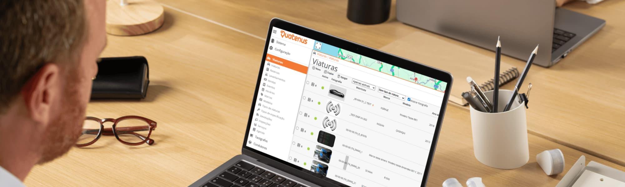 User working on a laptop with the Quatenus platform open on vehicle management and operational control